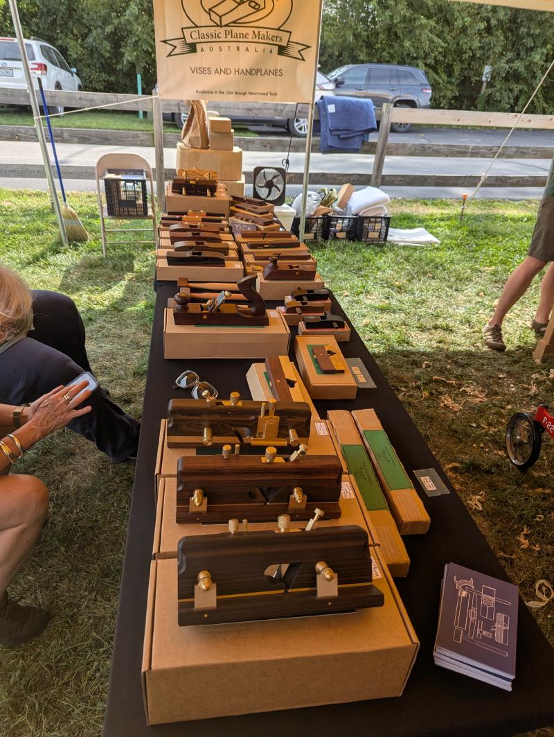 Classic wooden planes with brass and steel on a display table with a company banner in the background.