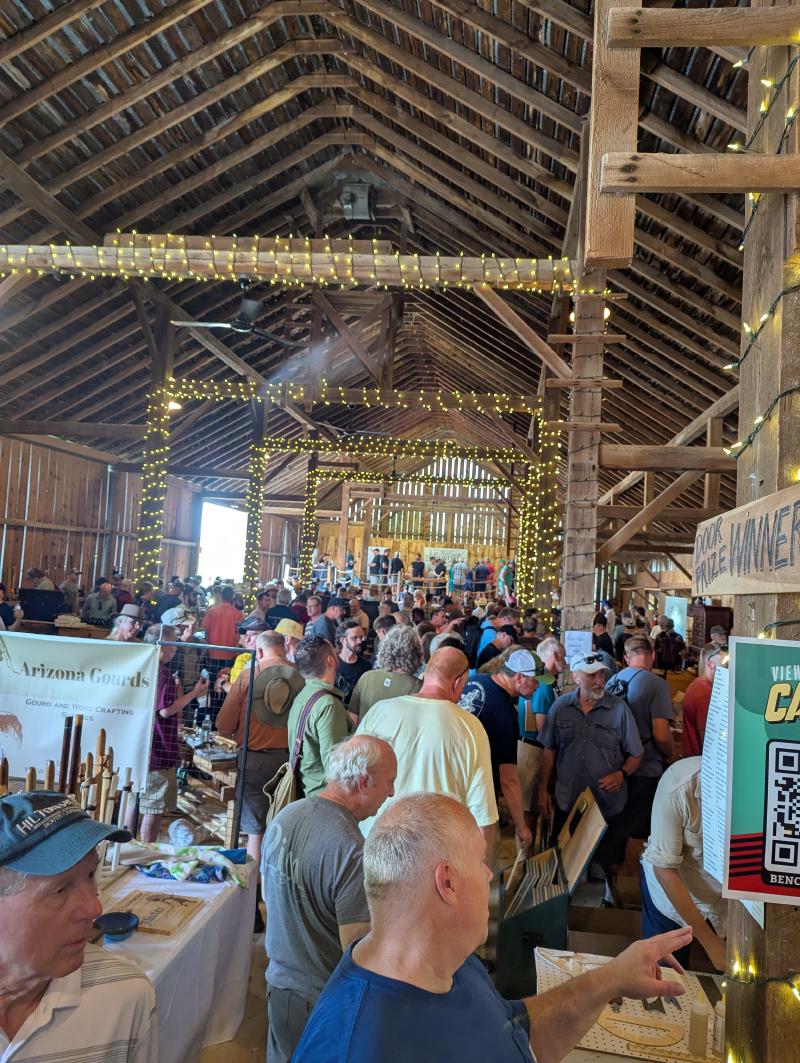 An old barn with a light ropes on the pillars and just packed with people.